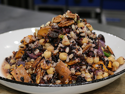 Vegan winter salad with roasted sweet potato, raisins & toasted pecans dressing with a cranberry & orange dressing