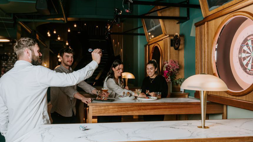 group of people enjoying darts sport in a pub